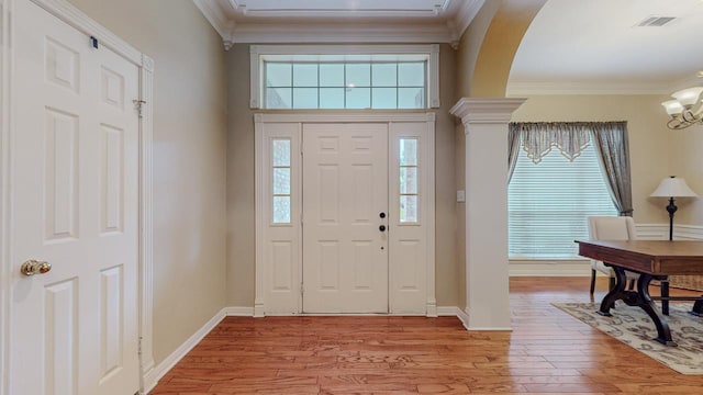 7640 Merion Dr, Beaumont, TX 77707 - foyer entrance with crown molding, light wood-style floors, a chandelier, and arched walkways