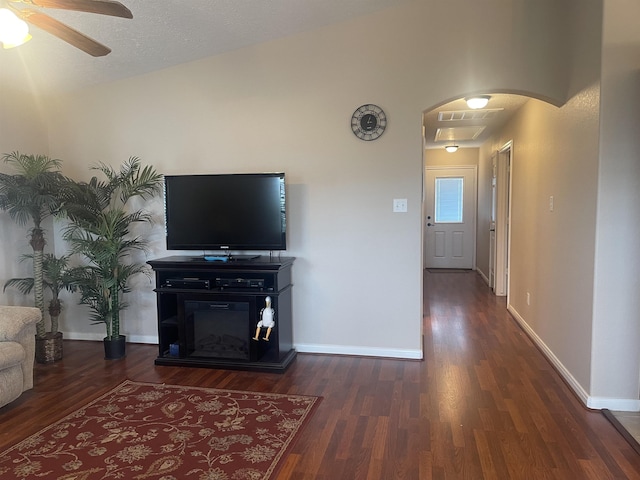 unfurnished living room featuring vaulted ceiling, ceiling fan, and dark hardwood / wood-style floors