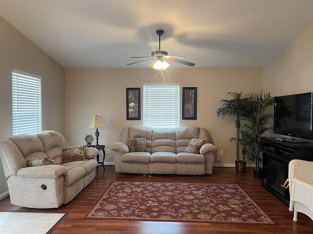 living room featuring ceiling fan, wood-type flooring, and a textured ceiling