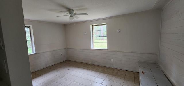 unfurnished room with ceiling fan, crown molding, and a wealth of natural light