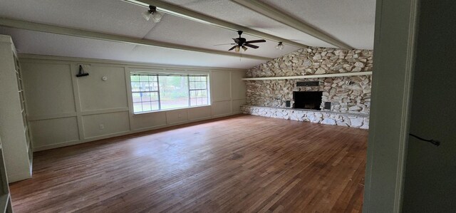 unfurnished living room with a fireplace, hardwood / wood-style floors, lofted ceiling with beams, and ceiling fan