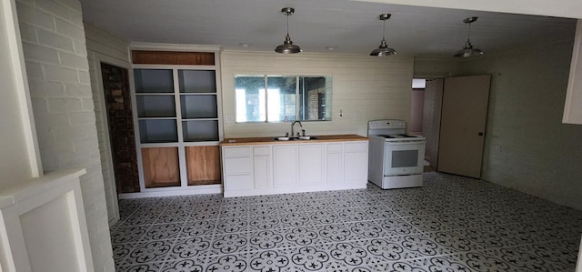 kitchen with sink, wooden counters, white range with electric cooktop, decorative light fixtures, and wooden walls