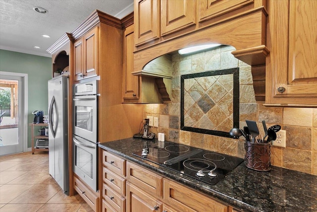 kitchen featuring backsplash, crown molding, stainless steel appliances, and dark stone counters