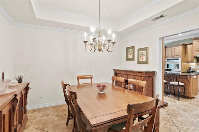 dining space featuring light tile patterned flooring, a tray ceiling, and an inviting chandelier