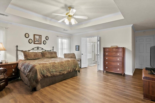 bedroom with hardwood / wood-style floors, ceiling fan, a raised ceiling, and ornamental molding