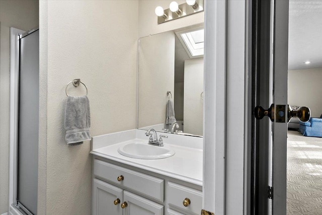 bathroom with vanity and a shower with door