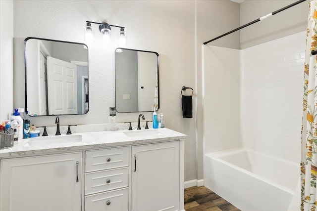 bathroom with hardwood / wood-style flooring, vanity, and shower / bath combo