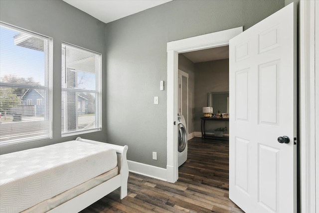 bedroom with washer / clothes dryer, dark hardwood / wood-style flooring, and multiple windows