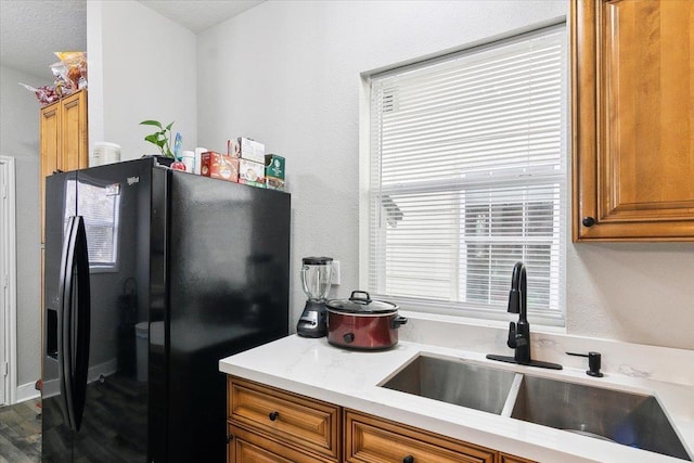 kitchen featuring sink and black fridge with ice dispenser