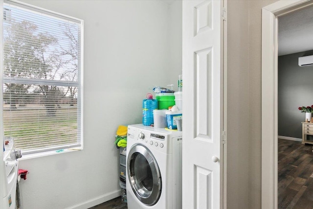 laundry area featuring washer / clothes dryer, a wall mounted AC, and dark hardwood / wood-style flooring