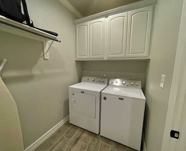 laundry area featuring separate washer and dryer, cabinets, and ornamental molding