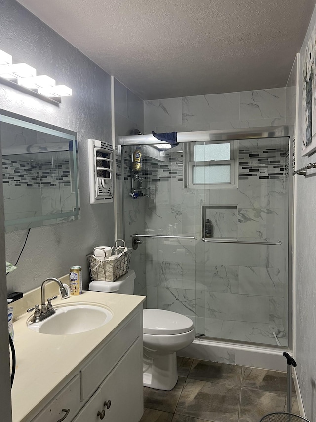 bathroom with vanity, toilet, an enclosed shower, and a textured ceiling