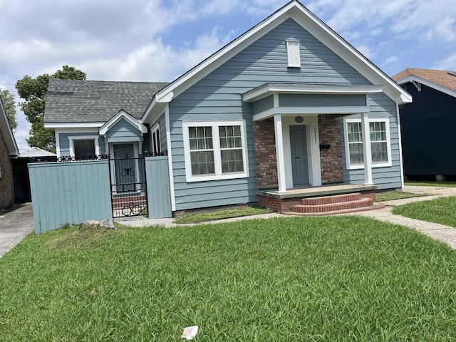 bungalow-style house with fence, a gate, a shingled roof, and a front lawn