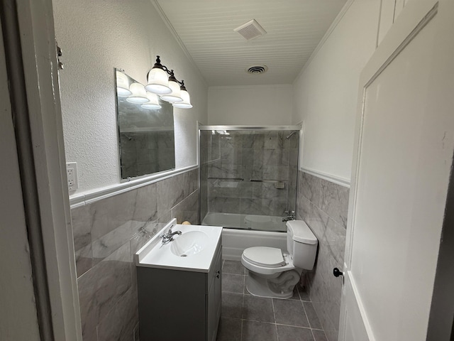 full bathroom featuring vanity, tile patterned floors, toilet, and tile walls