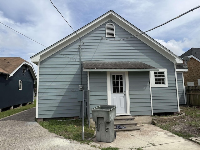rear view of house with fence and entry steps