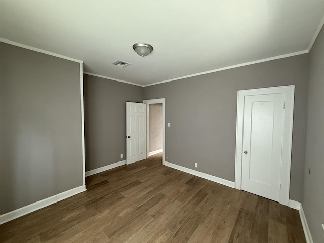 unfurnished bedroom with baseboards, wood finished floors, and visible vents