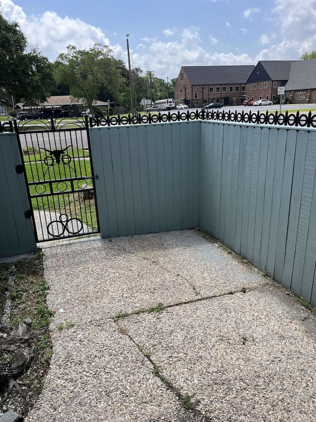view of patio with a gate, fence, and a residential view