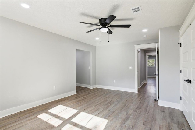 unfurnished room featuring ceiling fan, a textured ceiling, and light wood-type flooring