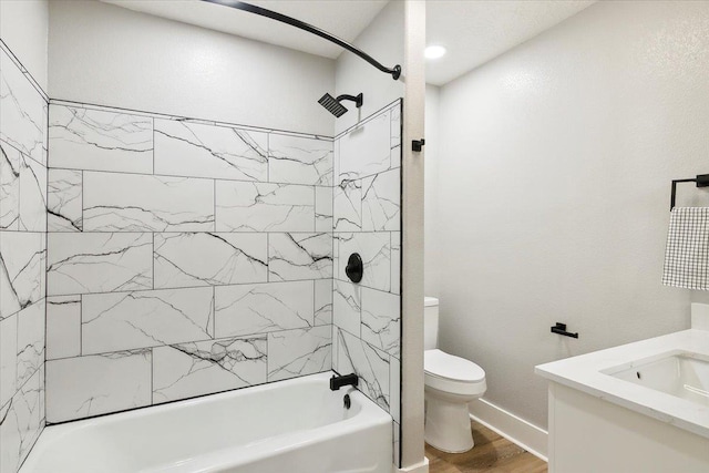 full bathroom featuring vanity, toilet, wood-type flooring, and tiled shower / bath