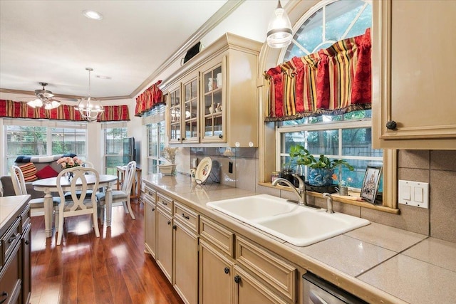 kitchen featuring cream cabinetry, pendant lighting, a sink, and light countertops
