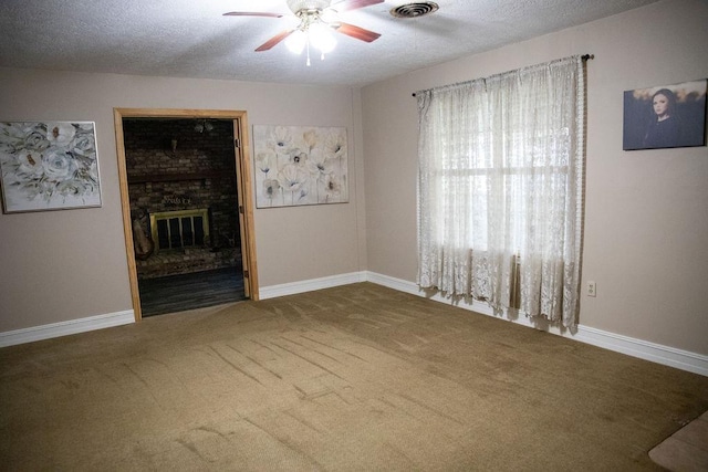 interior space featuring a fireplace, a textured ceiling, carpet flooring, and ceiling fan