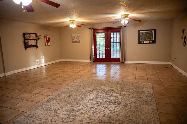 unfurnished room featuring tile patterned flooring, french doors, and a textured ceiling