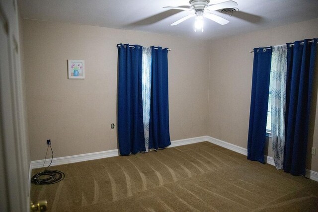 empty room featuring carpet flooring and ceiling fan