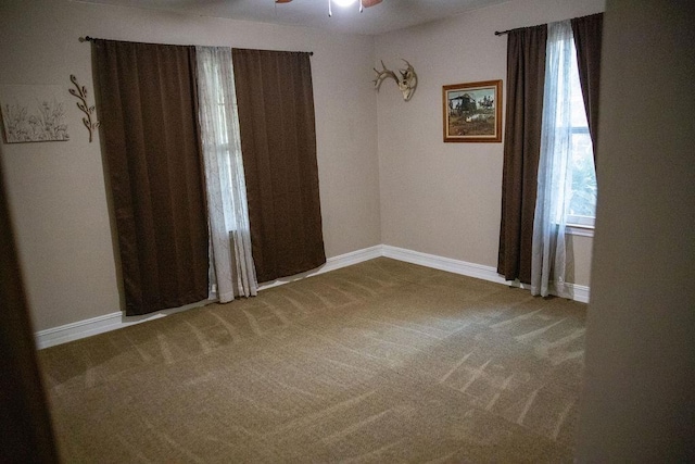 carpeted spare room featuring ceiling fan