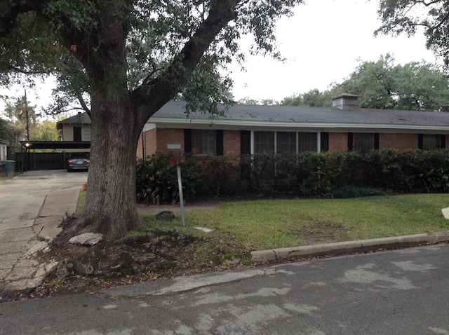 single story home featuring a carport and a front lawn