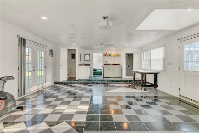 unfurnished living room with washing machine and clothes dryer, ceiling fan, and french doors