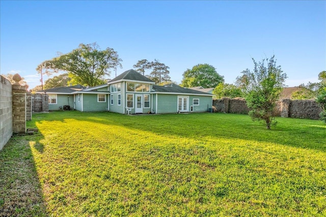 rear view of house featuring a yard