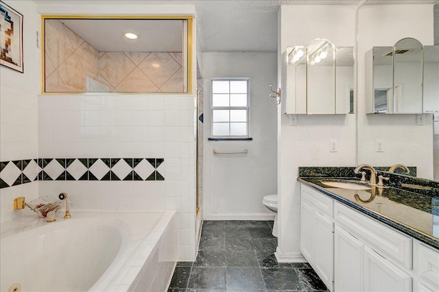 bathroom featuring vanity, a relaxing tiled tub, and toilet