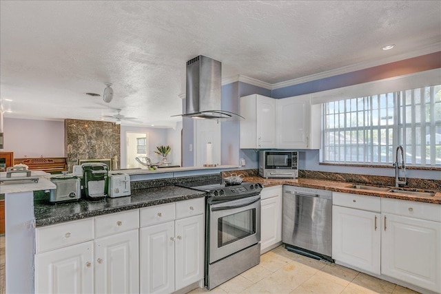 kitchen with wall chimney range hood, sink, a textured ceiling, white cabinetry, and stainless steel appliances