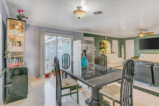 dining room featuring ceiling fan, ornamental molding, and a textured ceiling