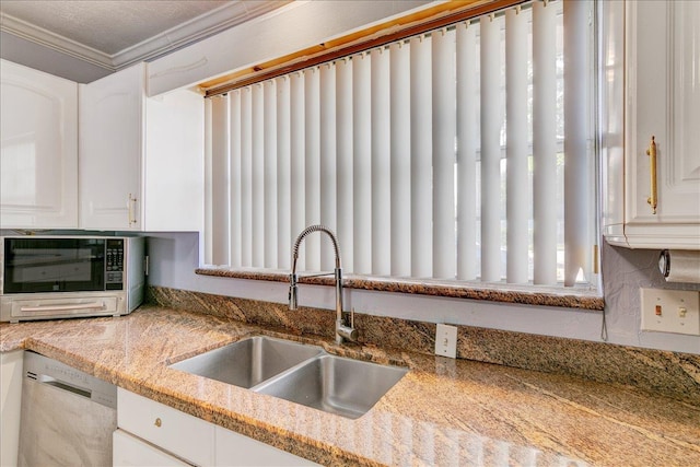 kitchen with white cabinets, sink, stainless steel dishwasher, ornamental molding, and light stone counters