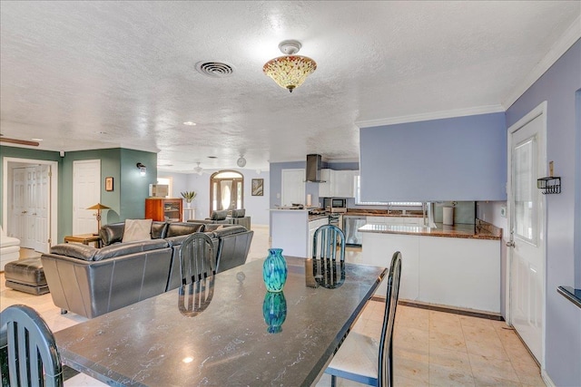 dining area featuring a textured ceiling, crown molding, and a healthy amount of sunlight