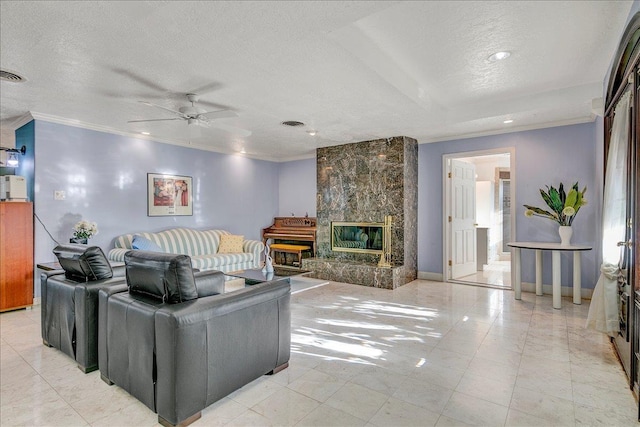 living room featuring ceiling fan, a premium fireplace, a textured ceiling, and ornamental molding