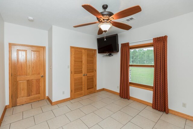 114 Holmes Rd, Lumberton, TX 77657 - unfurnished bedroom featuring a closet, baseboards, a ceiling fan, and light tile patterned flooring