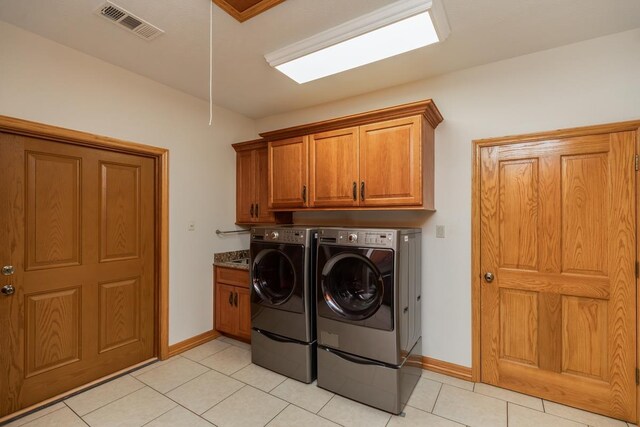 114 Holmes Rd, Lumberton, TX 77657 - laundry area featuring cabinet space, separate washer and dryer, light tile patterned flooring, and baseboards