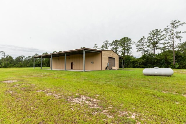 114 Holmes Rd, Lumberton, TX 77657 - back of house featuring a garage, a yard, and an outdoor structure