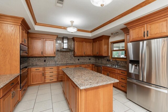 114 Holmes Rd, Lumberton, TX 77657 - kitchen with appliances with stainless steel finishes, wall chimney exhaust hood, light tile patterned flooring, a tray ceiling, and a sink