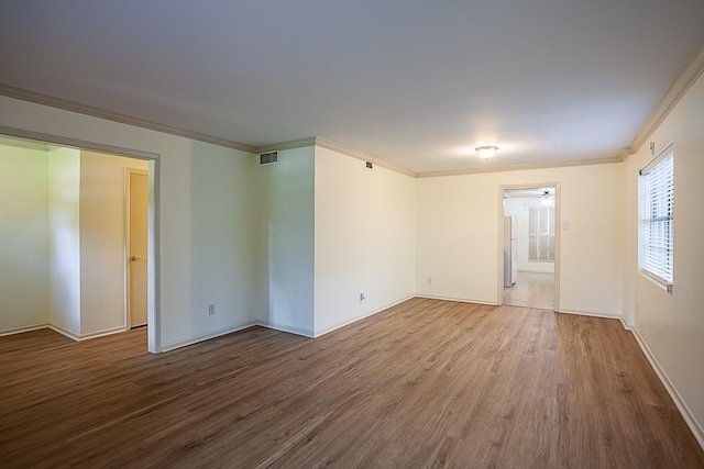 unfurnished room featuring crown molding and hardwood / wood-style floors