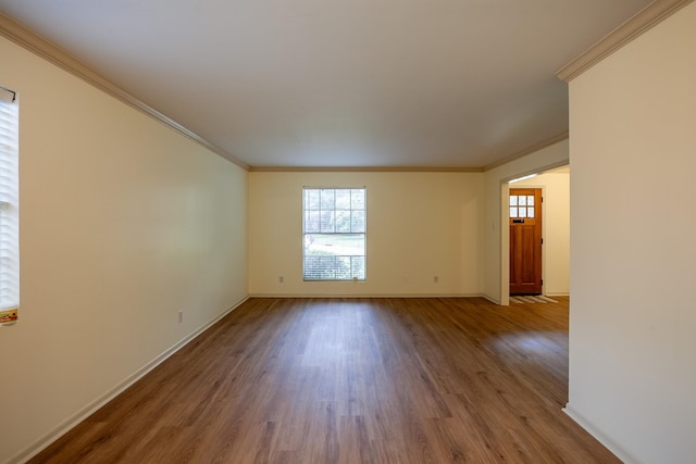 empty room featuring hardwood / wood-style floors, a healthy amount of sunlight, and ornamental molding