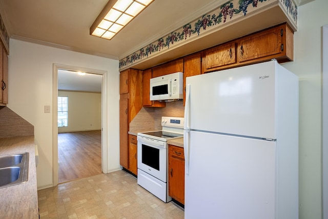 kitchen with sink, white appliances, crown molding, and tasteful backsplash