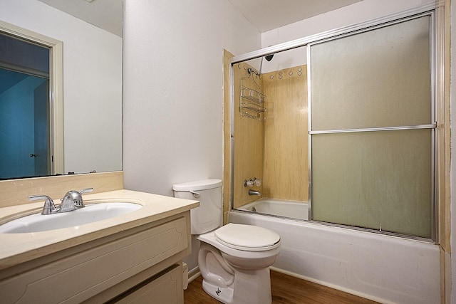 full bathroom featuring combined bath / shower with glass door, wood-type flooring, vanity, and toilet