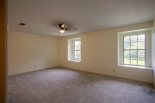 empty room with ceiling fan and carpet floors