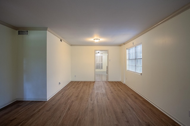 empty room featuring hardwood / wood-style floors and crown molding