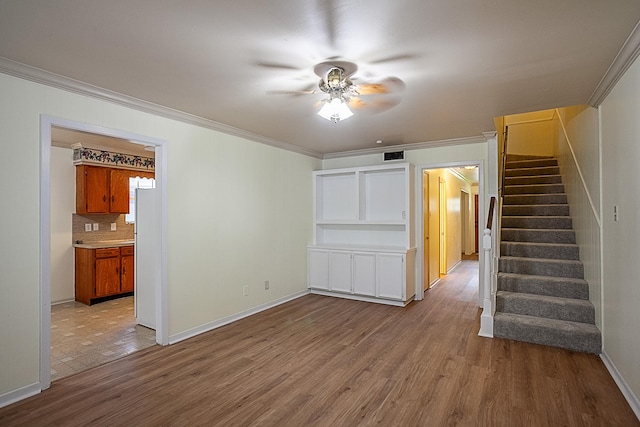 unfurnished living room with ceiling fan, light wood-type flooring, and crown molding