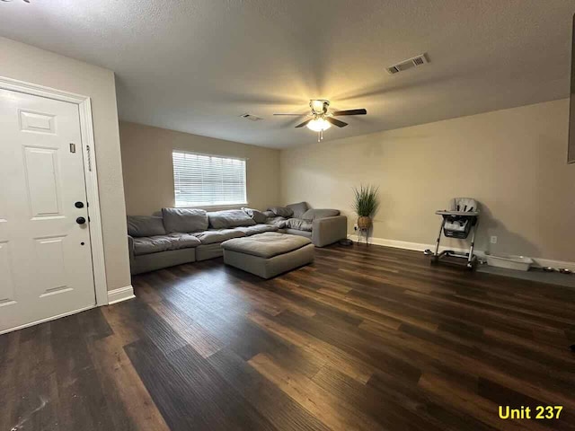 living room with ceiling fan and dark hardwood / wood-style floors