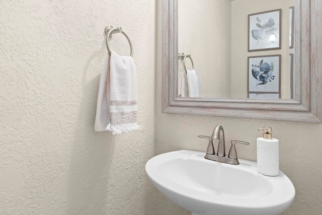 bathroom with a textured wall and a sink